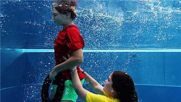 Leo und Marlene zeigen, wie man jemanden aus dem Schwimmbecken rettet.