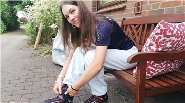 Frau beim Inlineranziehen auf einer Bank