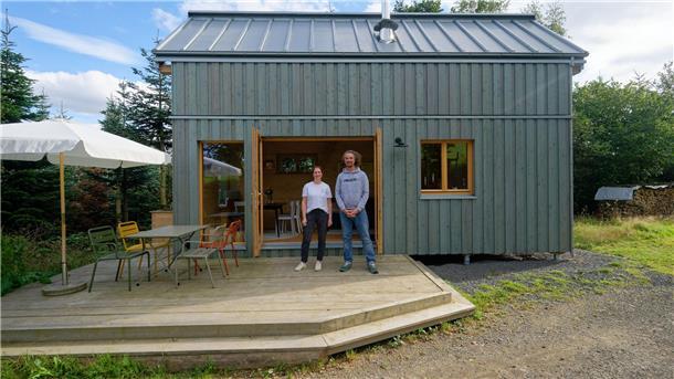 Tiny House: Das XS-Eigenheim als Öko-Idee im Klimawandel? Lisa Gelzhäuser (l) und Timo Gelzhäuser (r) stehen vor einem Muster ihres Tiny Houses: Es sind viele weitere Größen, Varianten, Erweiterungen und Dachformen möglich.