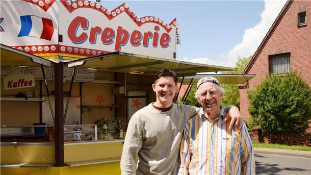 Ein jüngerer und älterer Herr stehen zusammen. Sie betreiben eine Crêperie in Burhave. 
