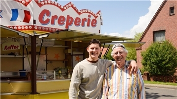 Ein jüngerer und älterer Herr stehen zusammen. Sie betreiben eine Crêperie in Burhave. 