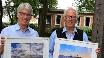 Lutz Ackermann (rechts) fotografiert immer, wenn er mit der Fähre von Sandstedt übersetzt. Bürgermeister Michael Kurz hat den Moderator überredet, die so entstandenen Fotos im Rathaus auszustellen.