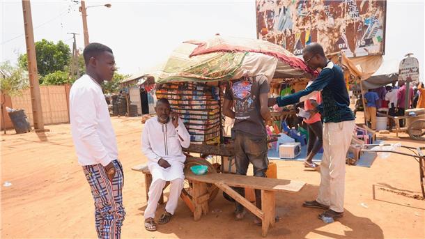 Männer stehen auf einem Straßenmarkt in Niamey.
