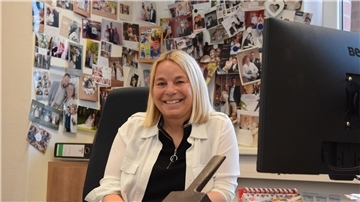Standesbeamtin Meike Poppe-Friedrich sitzt in ihrem Selsinger Büro vor einer Wand mit Fotos und Karten dankbarer Ehepaare.