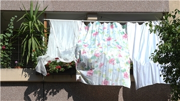 Manchmal muss zu außergewöhnlichen Lösungen gegriffen werden: Mit Tüchern schützen Bewohner die Pflanzen auf dem Balkon und ihre Wohnung vor der heißen Sonne.