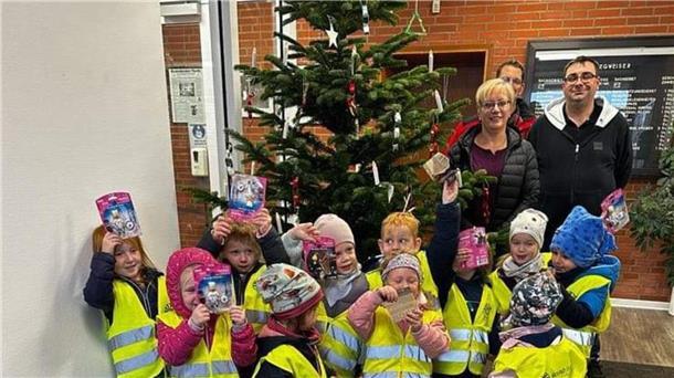 Ein Baum voller Wünsche steht im Ratshaus Rodenkirchen Manuela Manzke, Michael Lepies und Patrick Grimm freuen sich zusammen mit Kindern der Kita Regenbogen über die Weihnachtsbaumaktion.