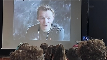 eine Leinwand auf der Marcus Bösch zu sehen ist.