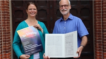 Mareen Osterloh und Gebhard von Hirschhausen freuen sich über das erste große, gemeinsame Projekt. Hier mit Konzertplakat und der Abschrift der "Schöpfung" von Benedict Kraus.
