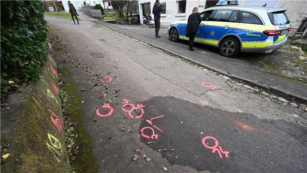 Markierungen der Spurensicherung der Polizei sind am Tatort auf einem Weg angebracht.