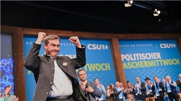 Markus Söder mit emporgereckten Armen.