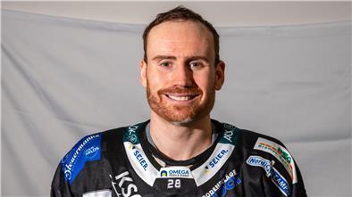 Eishockeyspieler im schwarzen Trikot vor weißer Wand