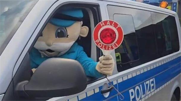 Ferdinands Feld Open-Air-Festival: Über zehntausend feiern zum Beat Eine Figur sitzt in einem Polizeiauto und hält eine Kelle mit der Aufschrift "Halt Polizei" in der Hand.