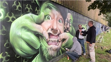 Mathias Blanck alias Ast (Mitte), Andreas Buschhardt alias Thoe (rechts) und Enrico Mau alias Demut (links unten) vor ihrem Werk „Keep Smiling“ in der Oststraße.