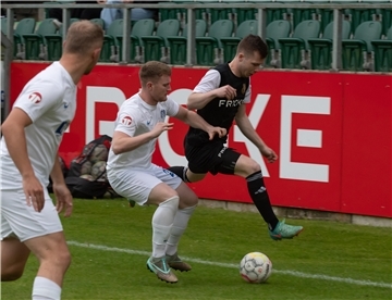 ein Mann in einem schwarzen Trikot und zwei Männer in einem weißen Trikot mit einem Fußball