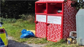 Zwischen und neben Altkleider- und Glascontainern liegen einige Altölkanister auf dem Boden.