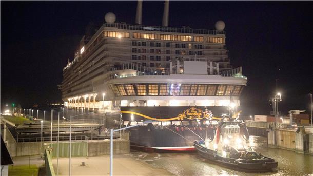 ein Schlepper zeiht ein Schiff durch eine Schleuse