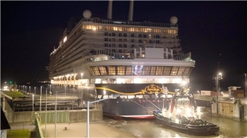 ein Schlepper zeiht ein Schiff durch eine Schleuse