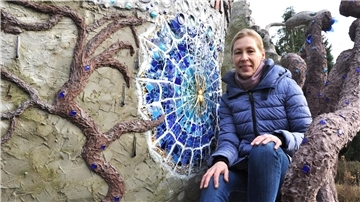 Frau sitzt neben einem Kunstwerk
