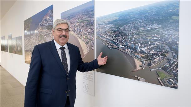 So hat sich Bremerhaven in 20 Jahren entwickelt Melf Grantz bei der Ausstellungseröffnung vor einem Bild von Wolfhard Scheer.