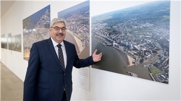 Melf Grantz bei der Ausstellungseröffnung vor einem Bild von Wolfhard Scheer.