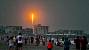 Menschen beobachten am Cocoa Beach im US-Bundesstaat Florida, wie die SpaceX-Rakete in Cape Canaveral abhebt.