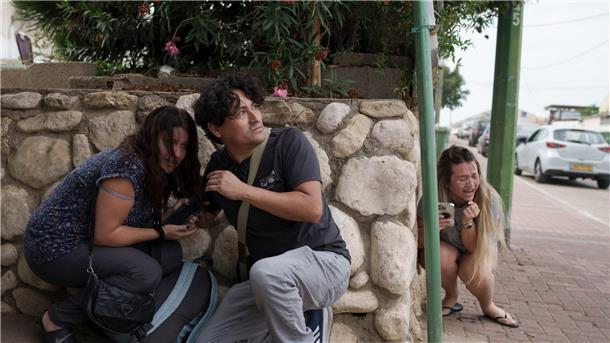 Psychologin: Bilder aus Israel können schwere Folgen haben Menschen gehen im südisraelischen Aschkelon vor Raketenbeschuss aus dem Gazastreifen in Deckung.