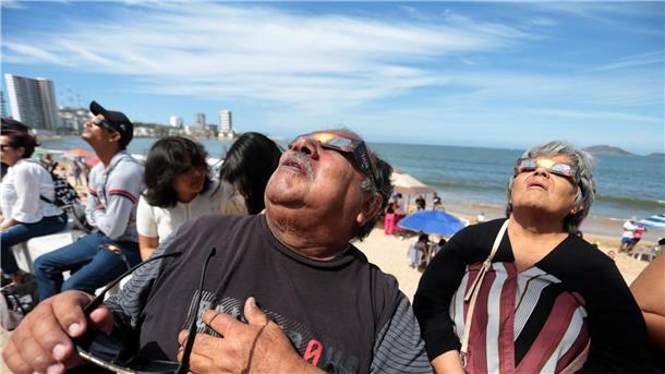 Millionen Menschen sehen totale Sonnenfinsternis Menschen haben sich im Hafen von Mazatlán in Mexiko versammelt, um die totale Sonnenfinsternis beobachten.