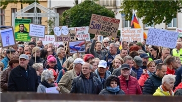 Menschen nehmen an einer Demonstration im Stadtzentrum von Frankfurt (Oder) teil - die Parolen auf den Schildern sind vielfältig.