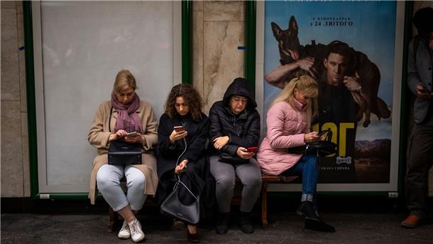 Menschen sitzen in einer U-Bahn-Station in Kiew. Die Station dient als Luftschutzbunker.