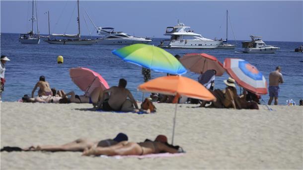 Menschen sonnen sich am Strand von Magaluf.