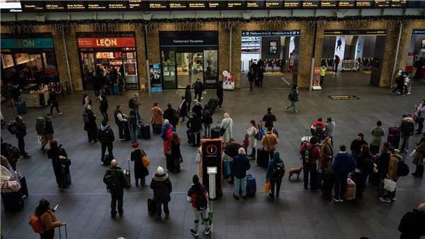 Menschen stehen an Anzeigetafeln im Londoner Bahnhof Kings Cross: Streiks behindern den Reiseverkehr zu Weihnachten erheblich.
