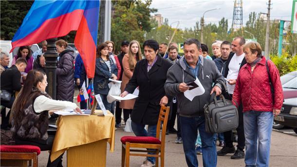 Menschen stellen sich in einer Reihe auf, um an einem Scheinreferendum in Luhansk teilzunehmen.