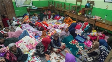 Menschen suchen in einer Schule Schutz, die nach dem Ausbruch des Vulkans Semeru als vorübergehende Unterkunft für die aus ihren Häusern Evakuierten dient.