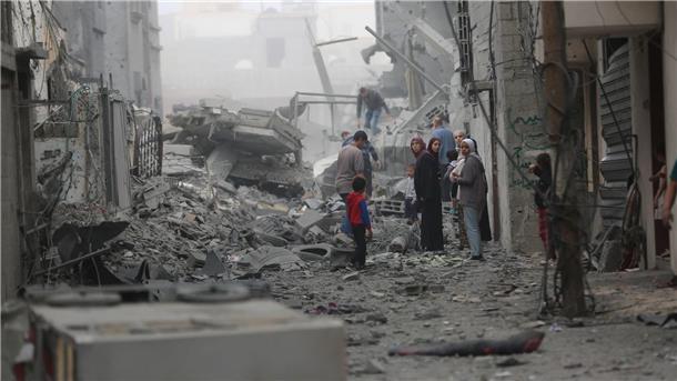 Israel kündigt „sofortige“ Aufstockung von Gaza-Hilfe an Menschen versammeln sich auf den Trümmern eines zerstörten Gebäudes nach einem Luftangriff im Flüchtlingslager Maghazi im Zentrum des Gazastreifens.