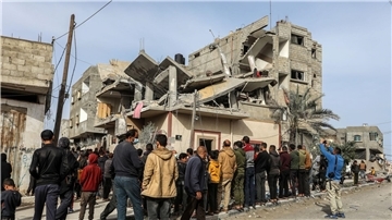 Menschen versammeln sich nach einem israelischen Luftangriff in Rafah um das zerstörte Haus einer Familie.