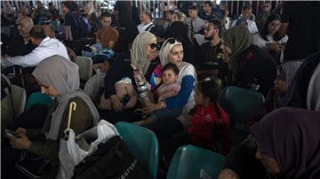 Menschen warten am Grenzübergang zwischen dem Gazastreifen und Ägypten.