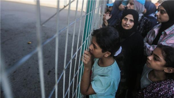 Zivilisten aus Gaza auf dem Weg nach Ägypten Menschen warten vor einem Zaun am Grenzübergang zwischen dem Gazastreifen und Ägypten.