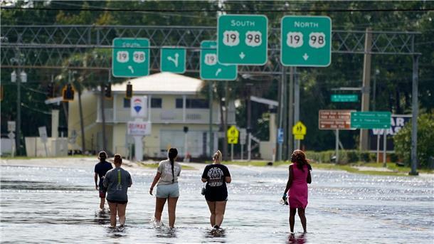 Sturmschäden durch „Idalia“ in Florida Menschen waten in Crystal River durch Hochwasser, nachdem „Idalia“ über das Gebiet gezogen war.