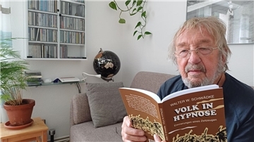 Michael Schwädke aus Schiffdorf hält ein Buch in der Hand.