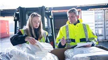 Michelle Weßlowski (links) und Steffen Lubinski vom Zoll kontrollieren auf dem Gelände eines Logistikunternehmens den Inhalt eines importierten Containers. 