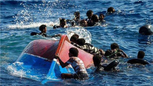 Küstenwache Italiens: Vier Migranten im Mittelmeer gestorben Migranten schwimmen neben ihrem umgestürzten Holzboot im Mittelmeer (Archiv).