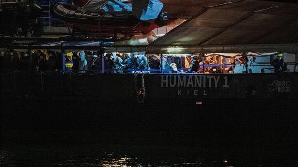 Migranten stehen an Deck der „Humanity 1“ im Hafen von Catania.