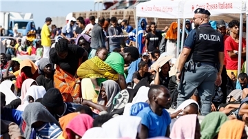 Migranten warten darauf, von der Insel Lampedusa auf das Festland gebracht zu werden.