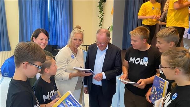 Fünf Schüler und zwei Lehrerinnen im Gespräch mit Ministerpräsident Stephan Weil.