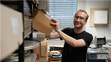 Ein Mann nimmt im Landesfilmarchiv Bremen eine Box mit Filmen aus dem Regal.