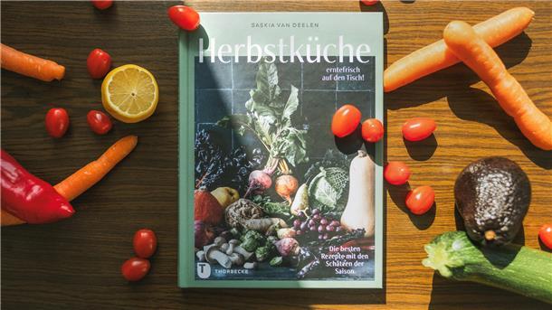 Das Buch "Herbstküche – erntefrisch auf den Tisch", umgeben von Gemüse.