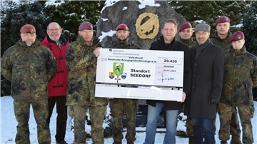 Mit dem höchsten Sammelergebnis in Niedersachsen unterstützt die Bundeswehr aus Seedorf den Volksbund. Oberst Eiko Zuckschwerdt (Dritter von links) überreicht den symbolischen Scheck.