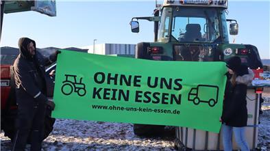 Mit der Aufschrift von diesem Banner wollen die Landwirte vor dem Rewe-Zentrallager in Sottrum ein Zeichen setzen.