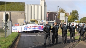 Mit einer Sitzblockade protestieren Aktivisten vor der Zufahrt eines Hafendienstleisters in Bremen-Walle. 