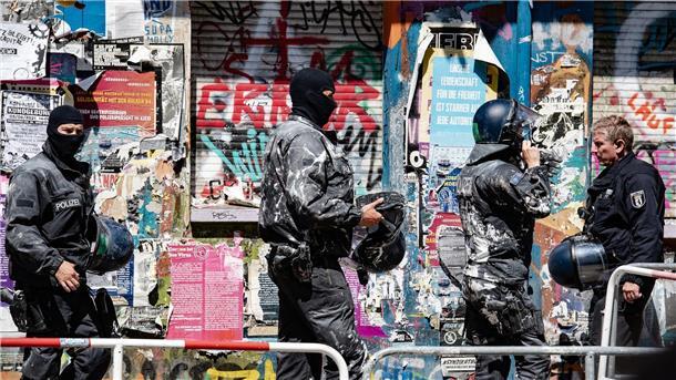 Mehrheit der Deutschen hält Linksextremismus für gefährlich Mit Farbe beworfene Polizeibeamte verlassen das Haus Nr. 94 in der Rigaer Straße in Berlin.